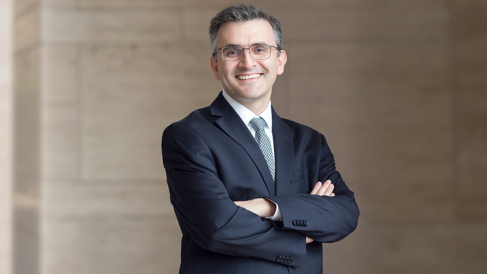 Masoud Sharif wearing a suit smiling at camera