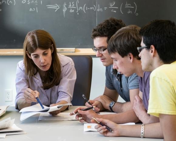 A group of Caltech students engage in a classroom discussion